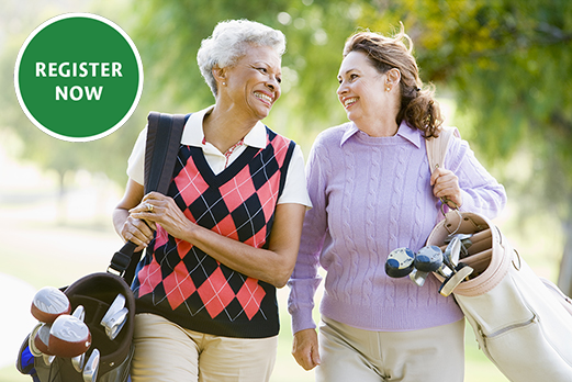 Two women walking and carrying golf clubs